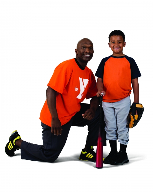 Volunteer with a child holding baseball gear