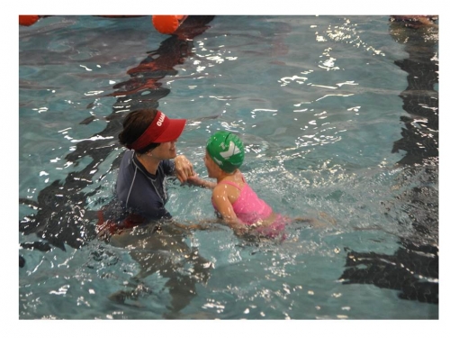 coach teaching a child to swim
